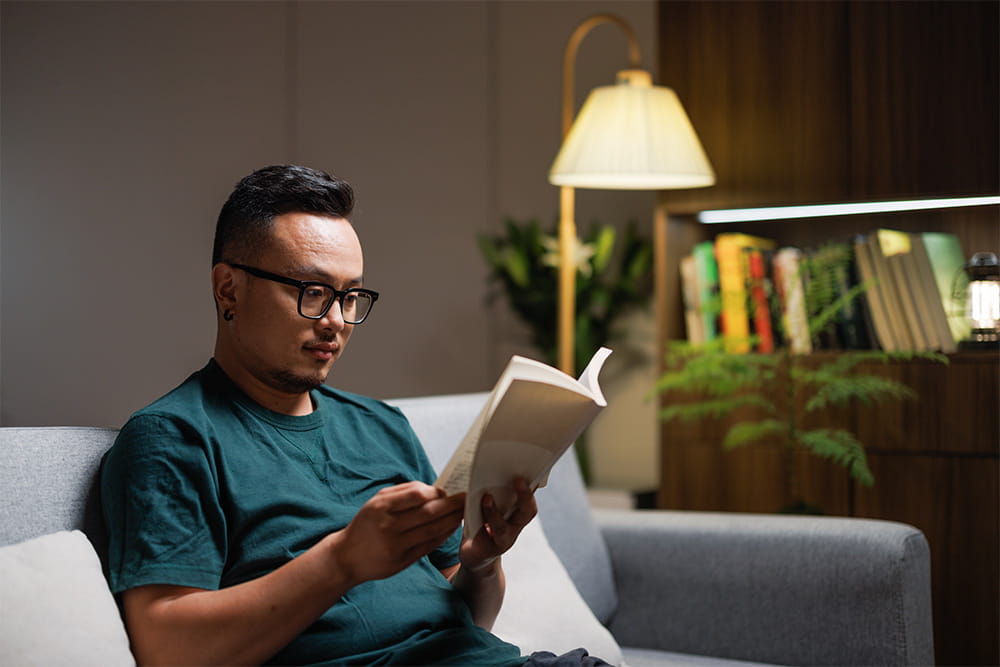 ソファに座り読書をしている男性